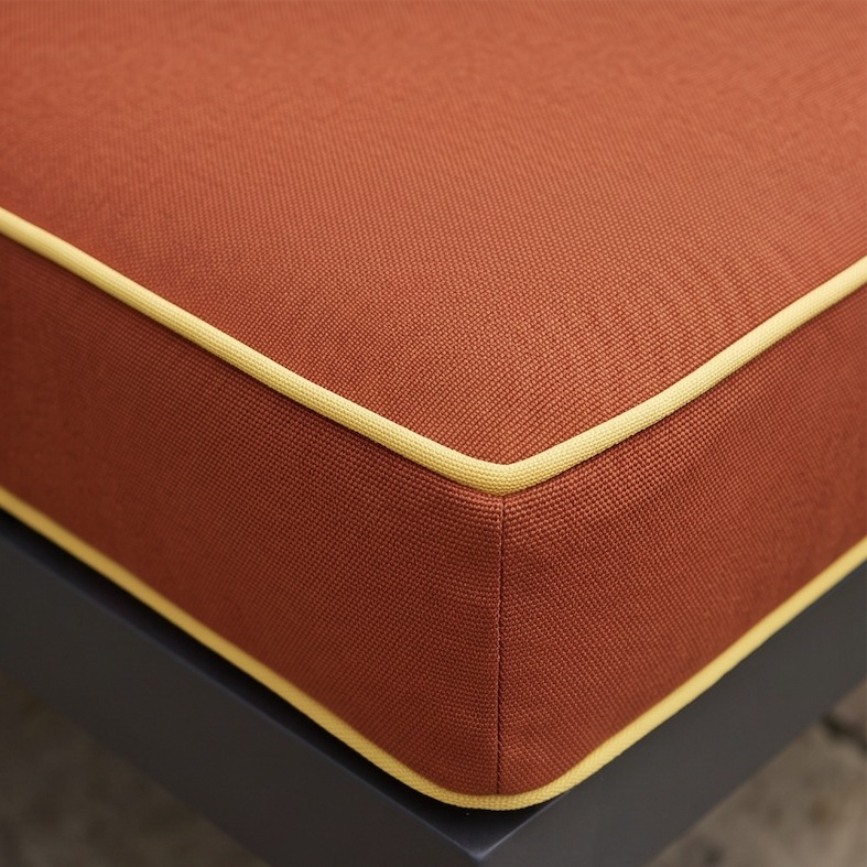 Close-up of a Cushiere cushion corner in Canvas Terracotta with a Canvas Buttercup contrast pipe