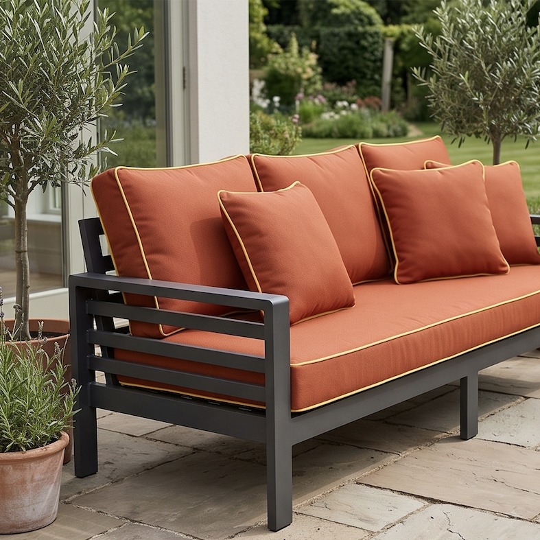 Cushiere outdoor sofa cushions in Canvas Terracotta with a Canvas Buttercup contrast pipe, photographed on delivery
